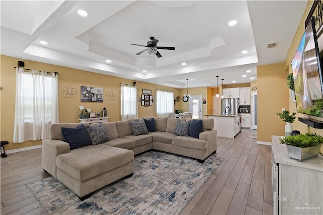 9713 Alexis Ave, Harlingen, TX 78552 - living room featuring a tray ceiling, light wood-type flooring, recessed lighting, and ceiling fan