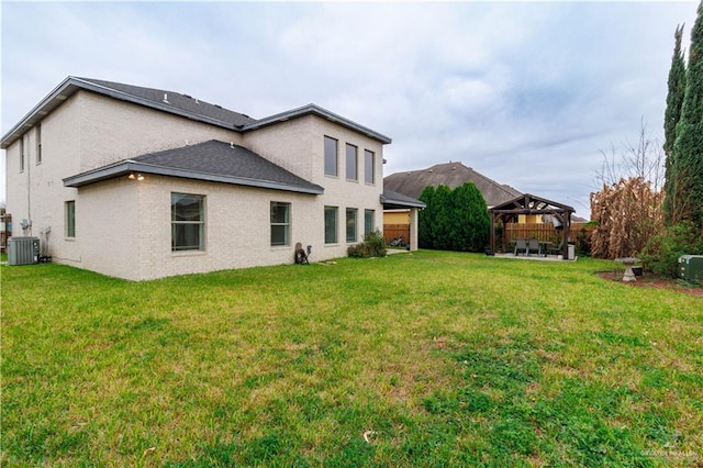 rear view of house with a yard, central AC unit, and a gazebo