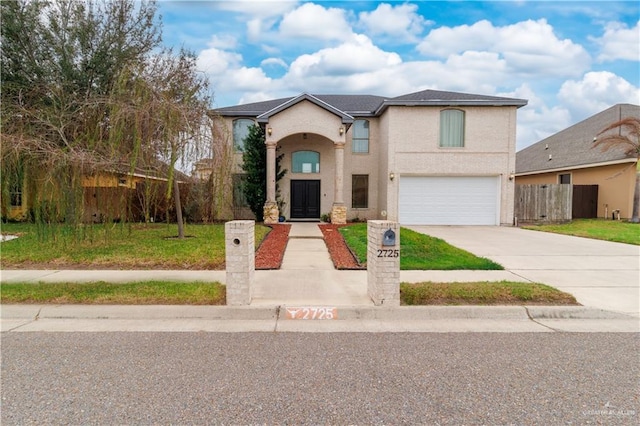 traditional-style home with an attached garage, fence, and concrete driveway