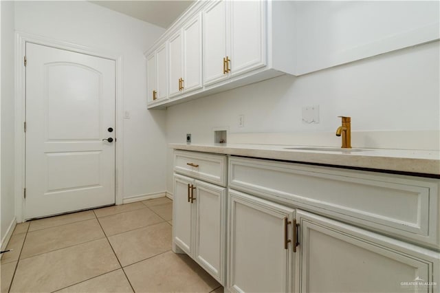 laundry room with light tile patterned floors, cabinet space, hookup for an electric dryer, washer hookup, and a sink