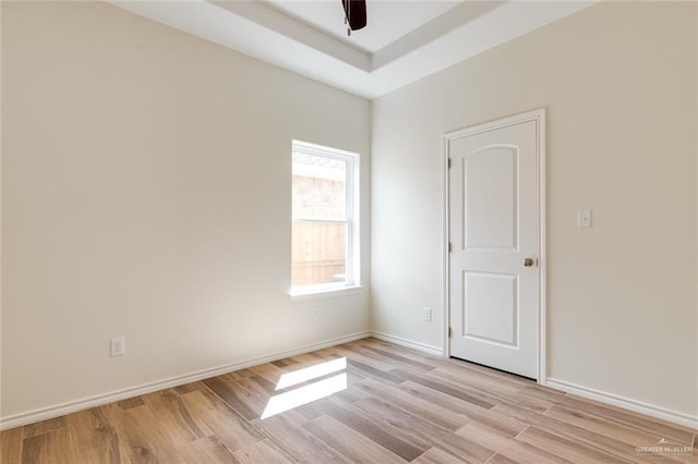 unfurnished room featuring light wood-type flooring, baseboards, and a ceiling fan