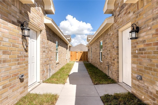 view of property exterior with fence and brick siding