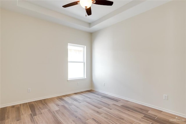 unfurnished room featuring light wood-style flooring, baseboards, and a ceiling fan