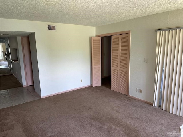 2901 Central Blvd Unit 807, Brownsville, TX 78520 - unfurnished bedroom featuring carpet floors, a closet, a textured ceiling, and baseboards