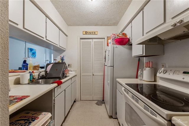 2901 Central Blvd Unit 807, Brownsville, TX 78520 - kitchen featuring white electric range oven, light flooring, under cabinet range hood, a textured ceiling, and white cabinetry