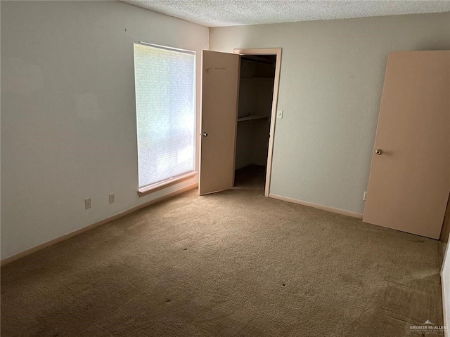 2901 Central Blvd Unit 807, Brownsville, TX 78520 - unfurnished bedroom featuring carpet flooring, a textured ceiling, a spacious closet, and baseboards
