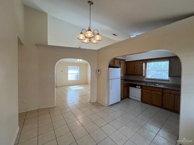 kitchen with sink, white appliances, light tile patterned floors, and hanging light fixtures