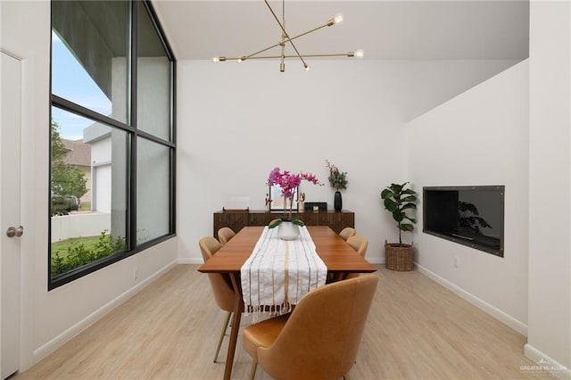 dining area with a chandelier, light wood-type flooring, and baseboards