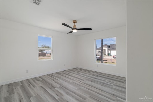 empty room with ceiling fan and light hardwood / wood-style flooring