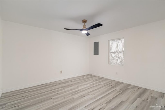 unfurnished room with ceiling fan, electric panel, and light wood-type flooring