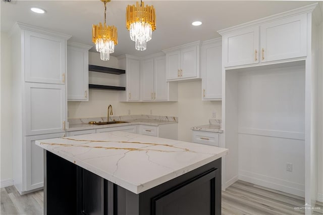 kitchen with sink, pendant lighting, white cabinets, and a kitchen island