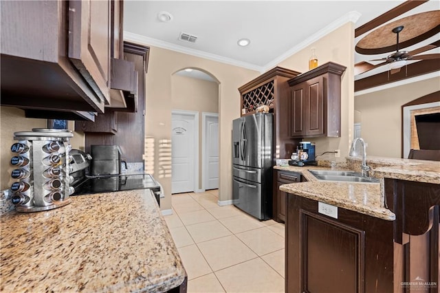 kitchen with dark brown cabinetry, stainless steel appliances, sink, ceiling fan, and crown molding