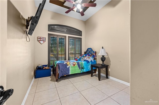 bedroom featuring ceiling fan, light tile patterned floors, and lofted ceiling