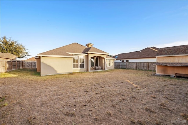 rear view of house featuring a yard