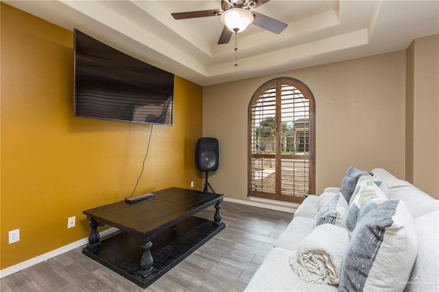 512 Frost Proof Dr, Weslaco, TX 78599 - living room with a tray ceiling, a ceiling fan, wood finished floors, and baseboards