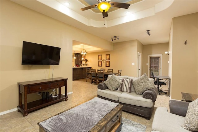 512 Frost Proof Dr, Weslaco, TX 78599 - living room with light tile patterned floors, a tray ceiling, ceiling fan, and baseboards