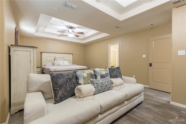 512 Frost Proof Dr, Weslaco, TX 78599 - bedroom featuring a tray ceiling, baseboards, wood finished floors, and a ceiling fan