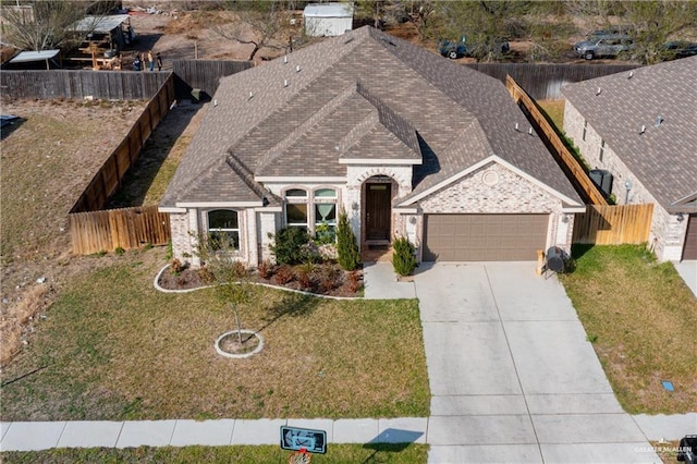 5524 Xenops Ave, Mcallen, TX 78504 - view of front facade with an attached garage, brick siding, concrete driveway, and roof with shingles