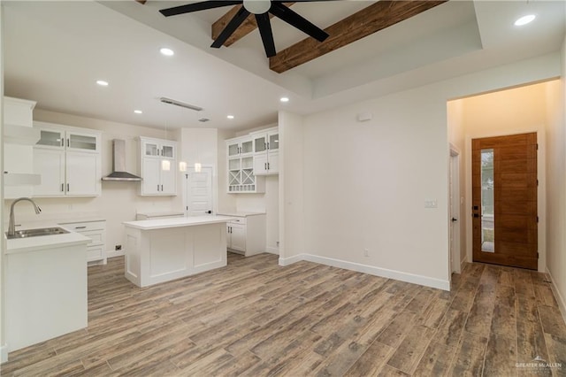 2211 Tomatillo Dr, Weslaco, TX 78596 - kitchen with wall chimney exhaust hood, ceiling fan, light wood finished floors, a center island, and beam ceiling
