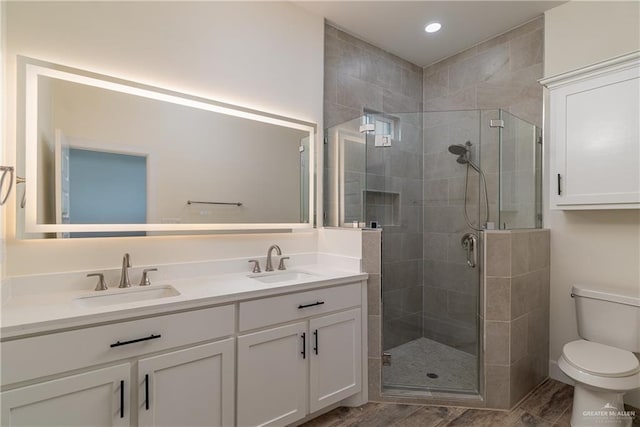 2211 Tomatillo Dr, Weslaco, TX 78596 - bathroom featuring double vanity, a stall shower, wood finished floors, and recessed lighting