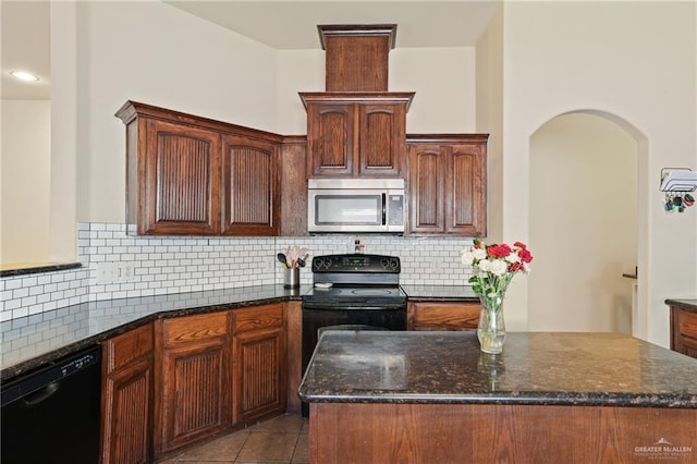 kitchen featuring decorative backsplash, black appliances, dark stone countertops, and light tile patterned flooring