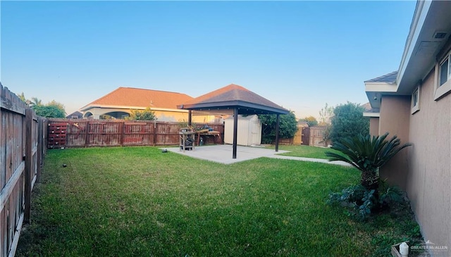 view of yard featuring a shed, a gazebo, and a patio