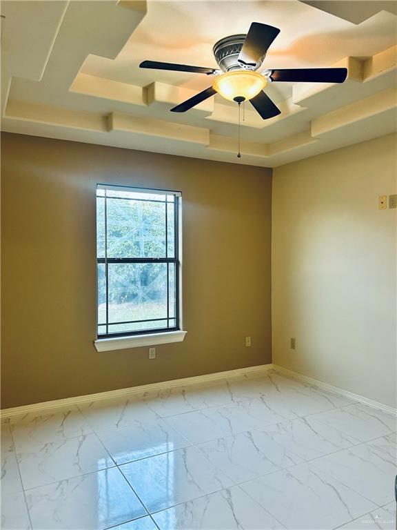 unfurnished room with a raised ceiling and ceiling fan