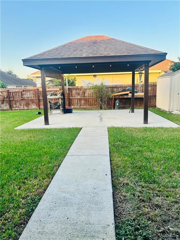 view of yard with a gazebo, a storage unit, and a patio area