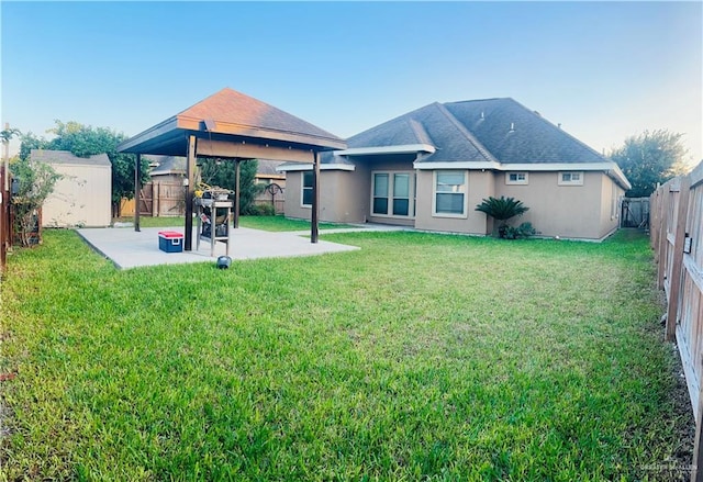 back of property featuring a gazebo, a yard, and a patio