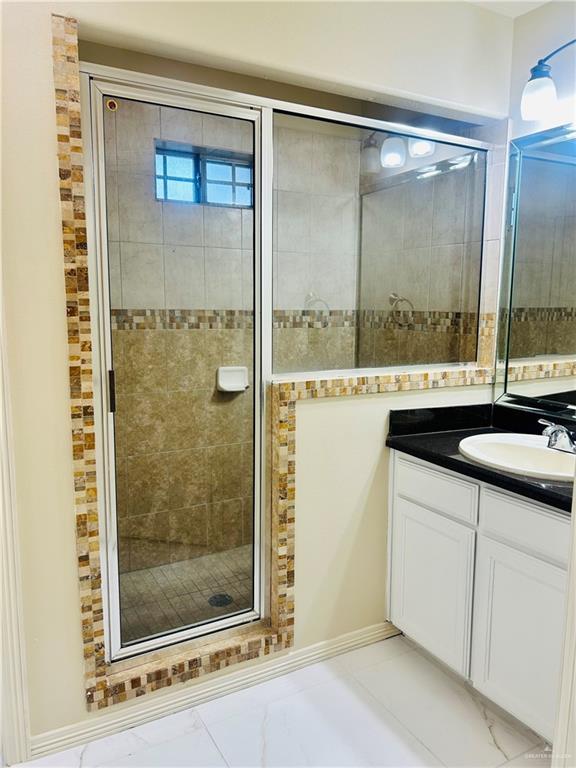 bathroom with vanity and a shower with shower door