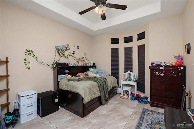 bedroom with a raised ceiling and a ceiling fan