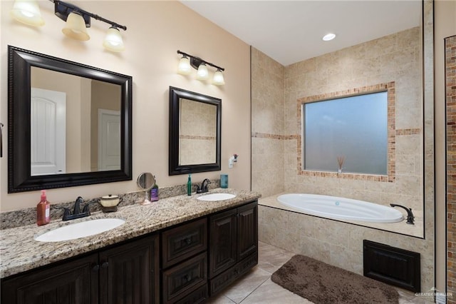 full bathroom featuring a garden tub, double vanity, tile patterned floors, and a sink