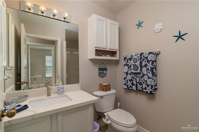 bathroom with vanity, toilet, and a shower with shower door