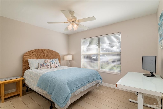 bedroom with multiple windows, ceiling fan, and light hardwood / wood-style floors