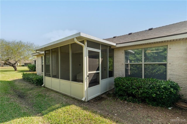 view of side of home with a yard and a sunroom