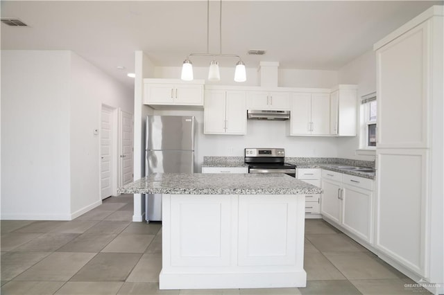 kitchen featuring a kitchen island, light stone counters, decorative light fixtures, white cabinets, and appliances with stainless steel finishes