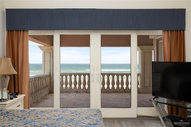 bedroom with hardwood / wood-style floors, access to outside, and multiple windows