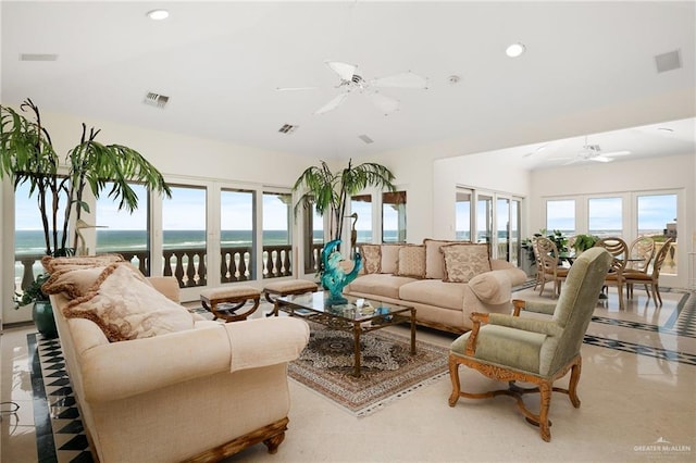 living room featuring ceiling fan and a water view