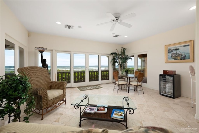 living room with ceiling fan and beverage cooler