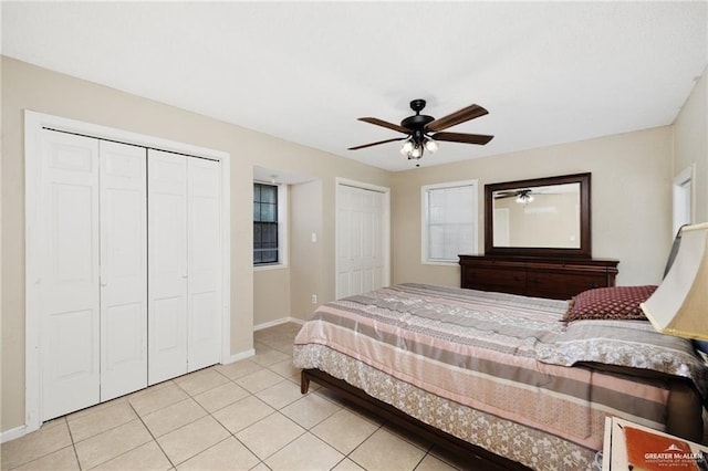 bedroom featuring light tile patterned floors, two closets, and ceiling fan