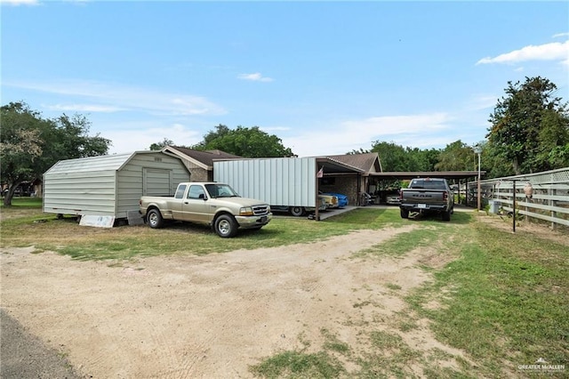 view of yard featuring a carport and an outdoor structure