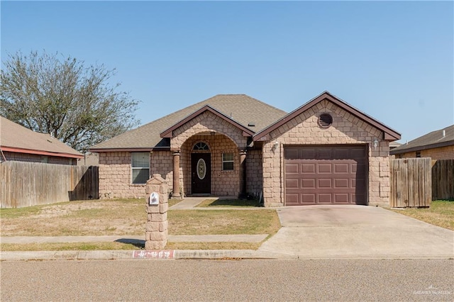 view of front of property featuring a garage, roof with shingles, concrete driveway, and fence