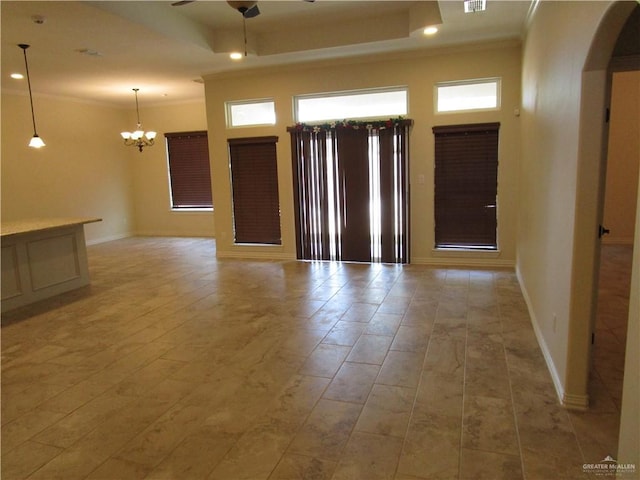 spare room with ornamental molding, a raised ceiling, and ceiling fan with notable chandelier