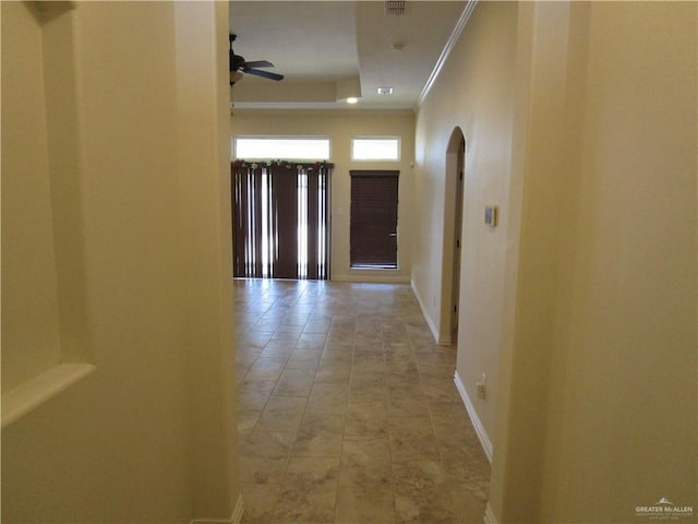 hallway featuring ornamental molding and a tray ceiling