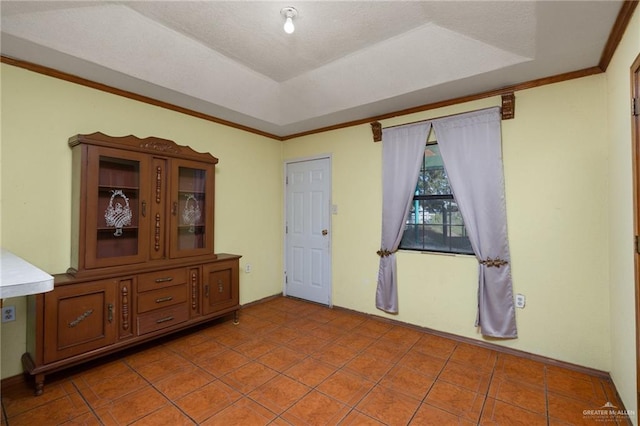 tiled empty room with a raised ceiling and crown molding