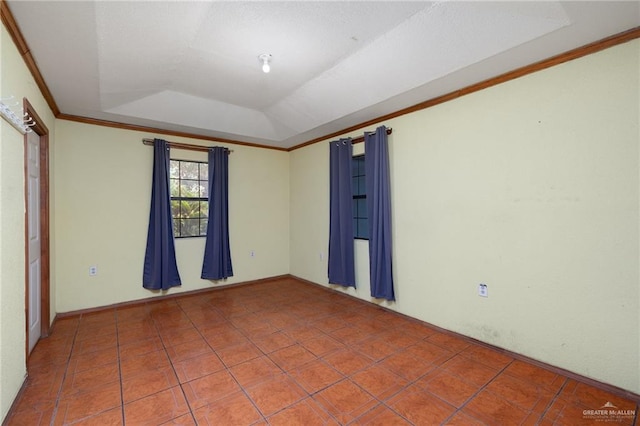 tiled spare room featuring a raised ceiling and ornamental molding