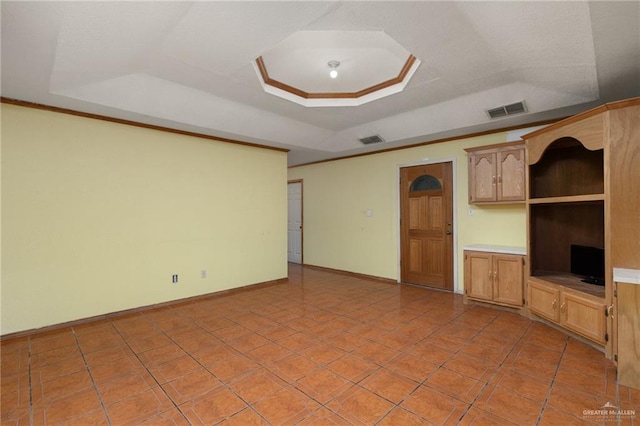 unfurnished living room with a tray ceiling and light tile patterned flooring