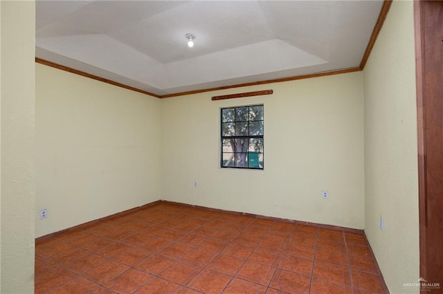 tiled empty room with a raised ceiling and crown molding