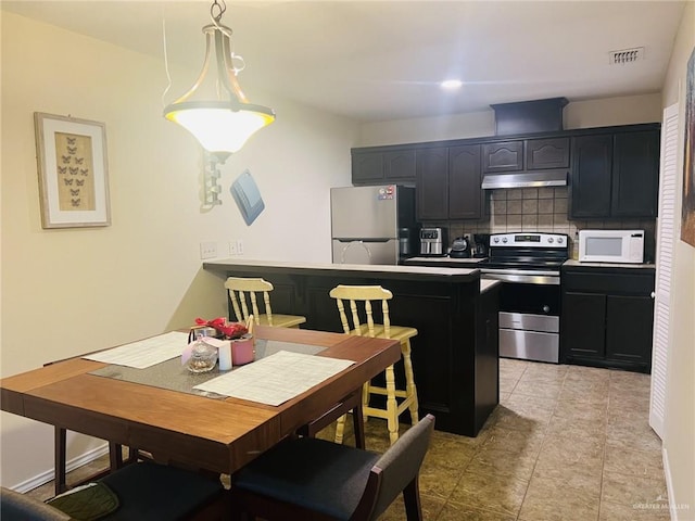 kitchen with backsplash, kitchen peninsula, hanging light fixtures, and stainless steel appliances