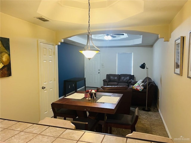 dining room featuring a raised ceiling and ceiling fan